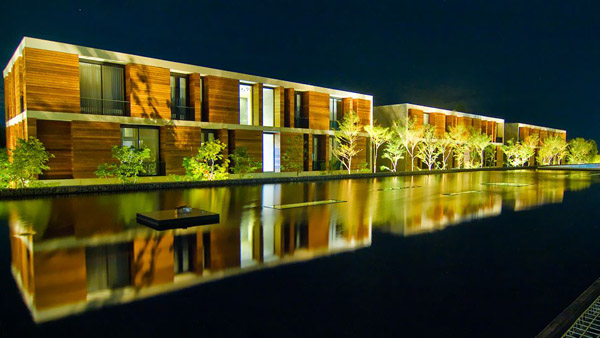 exterior-outdoor-pool-night, άποψη ξενοδοχείου, διώροφο ξενοδοχείο, φωτισμένη πισίνα ξενοδοχείου, μίνιμαλ πρόσοψη ξενοδοχείου